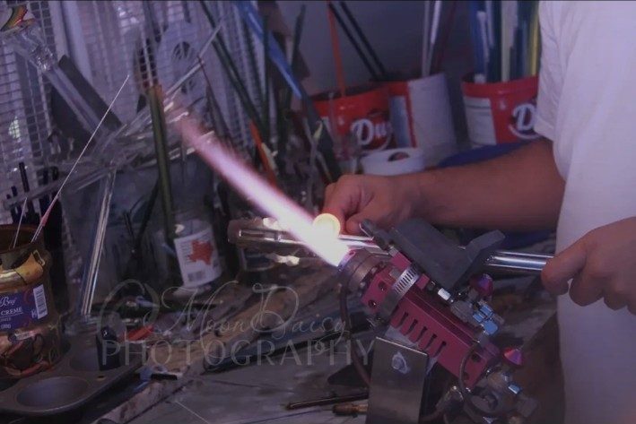 Wide view of Jose Valdes working at the glass bench