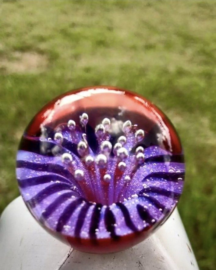 Purple and red borosilicate glass implosion marble by Jose Valdes